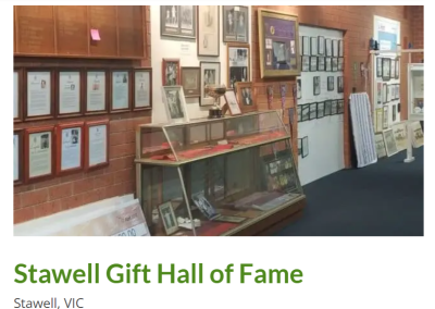 Interior view of the Stawell Gift Hall of Fame in Stawell, VIC, showcasing an array of framed photographs and plaques celebrating past winners and athletes. A glass display case holds trophies and memorabilia, highlighting the rich history of the iconic Stawell Gift race.