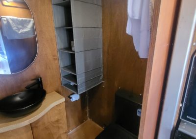 Compact and stylish bathroom in a brown caravan featuring modern fixtures, a black sink, and storage space at Stawell Hotel Motel Accommodation