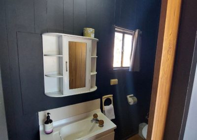 Modern bathroom with a white vanity and mirror cabinet, featuring natural light and sleek design at Stawell Hotel Motel Accommodation