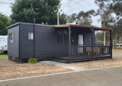 Modern black cabin with a spacious front porch, nestled in a natural setting at Stawell Hotel Motel Accommodation
