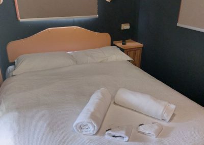 Cozy bedroom with a neatly made double bed, soft white linens, and bedside lighting at Stawell Hotel Motel Accommodation