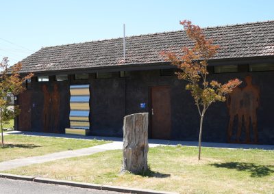Exterior view of modern amenities building with artistic metal sculptures and a rustic design at Stawell Hotel Motel Accommodation