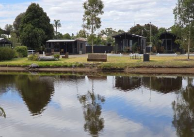 Scenic view of modern cabins surrounded by greenery, overlooking a tranquil lake at Stawell Hotel Motel Accommodation